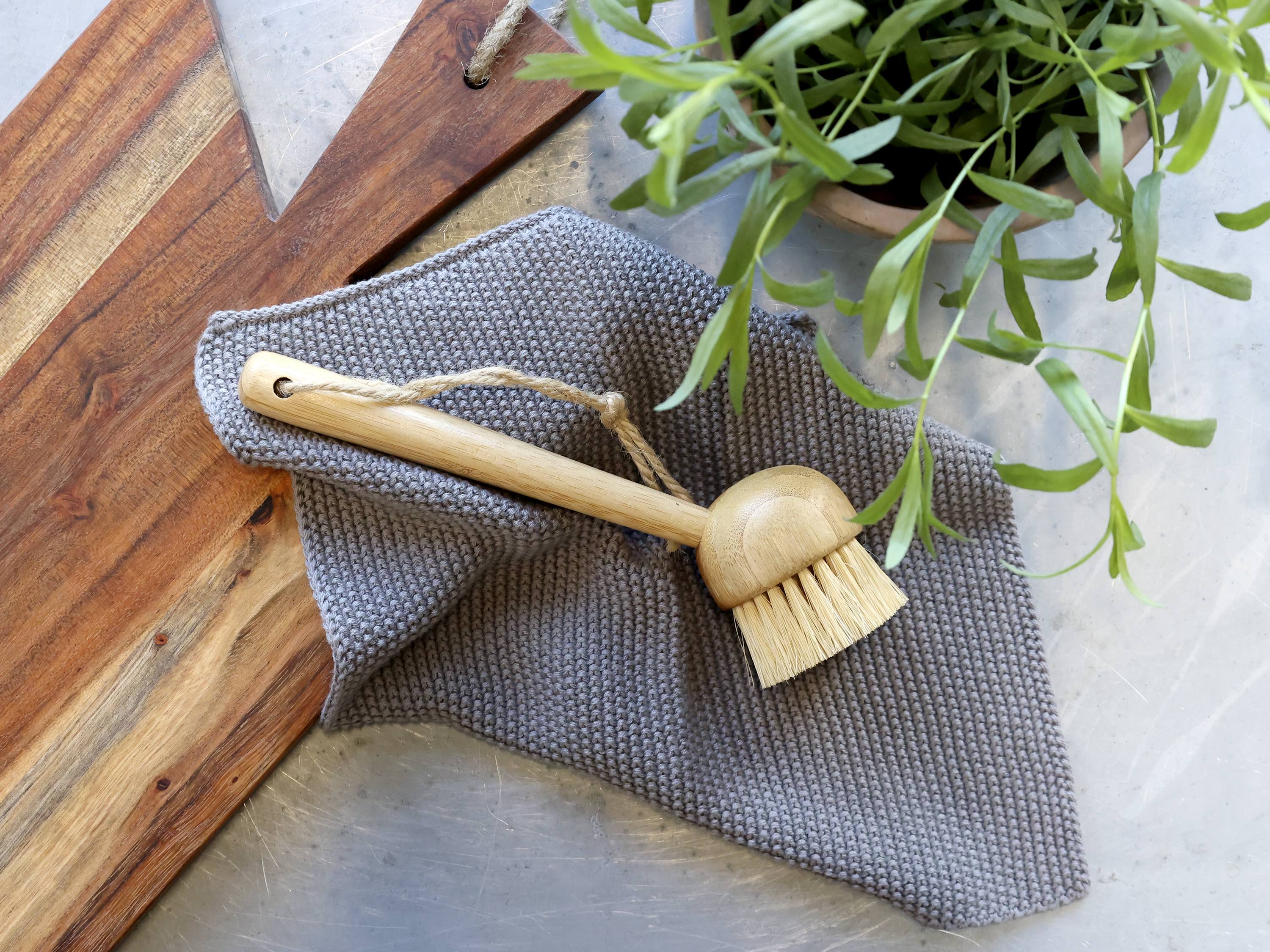 Ib Laursen Spülbürste aus Holz mit Naturborsten auf grauem gestricktem Küchentuch im skandinavischen Landhausstil arrangiert
