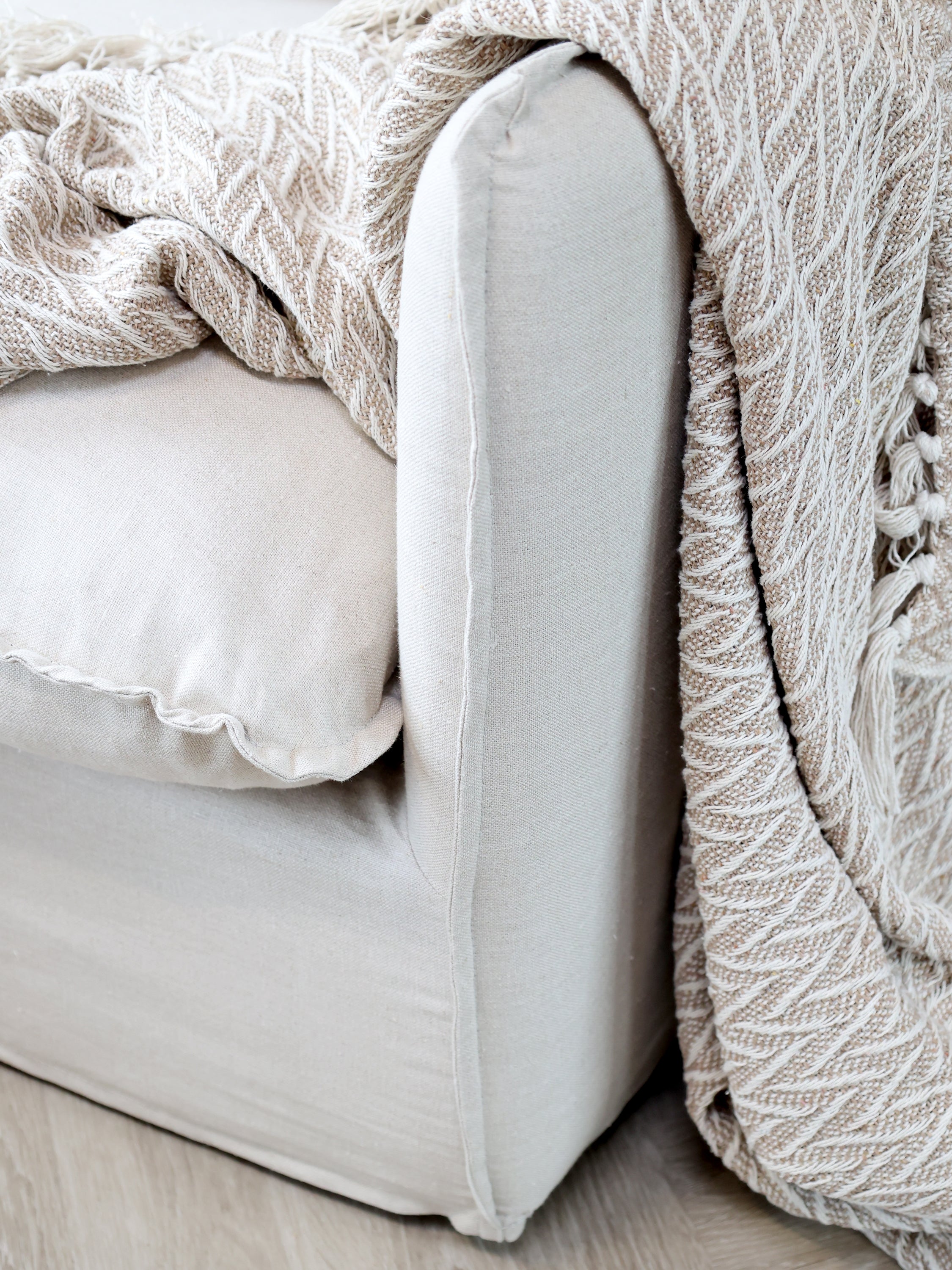 Chic Antique Aix Plaid Latte mit Fransen über Sofa im skandinavischen Wohnstil