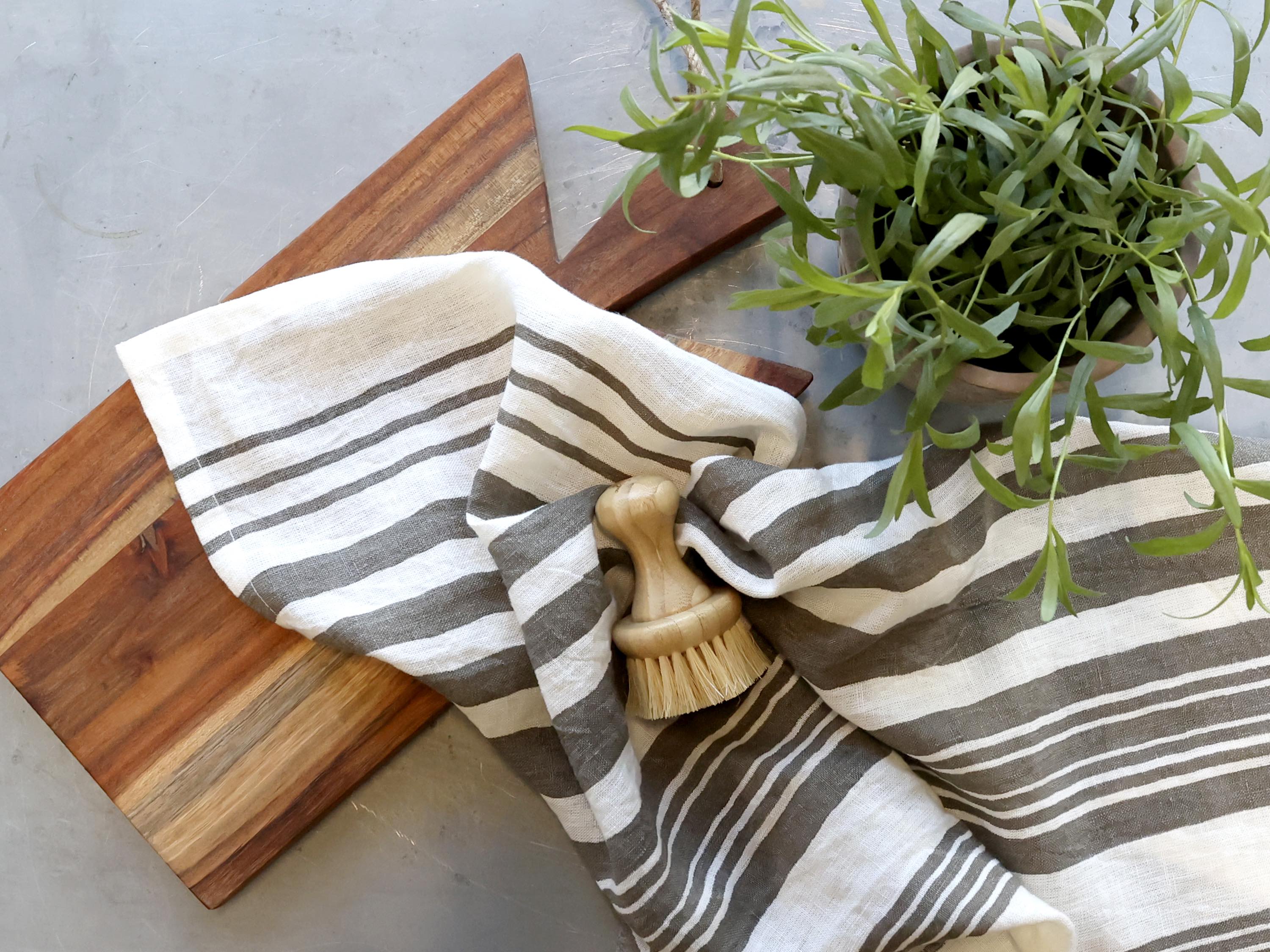Chic Antique Éternel Geschirrtuch mit grauen Barchant Streifen aus Leinen neben Holzbrett und Spülbürste im skandinavischen Küchenstil