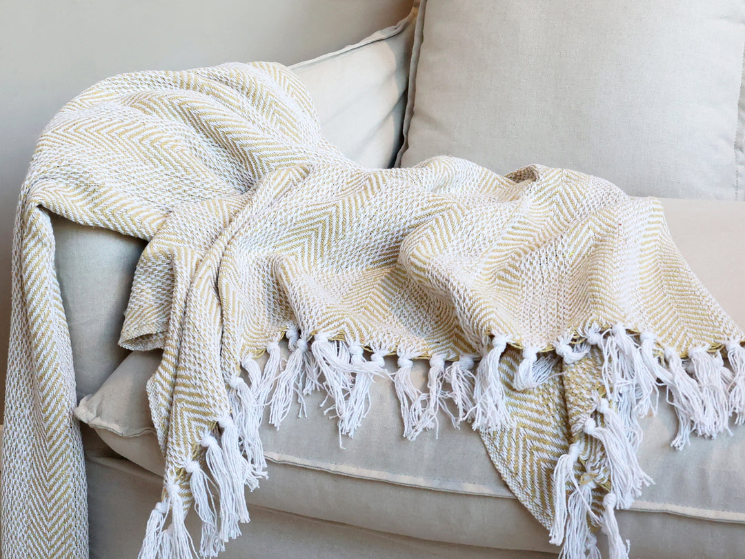 Chic Antique Plaid gold karamel mit Fransen als Tagesdecke auf Sofa im Hygge Wohnstil