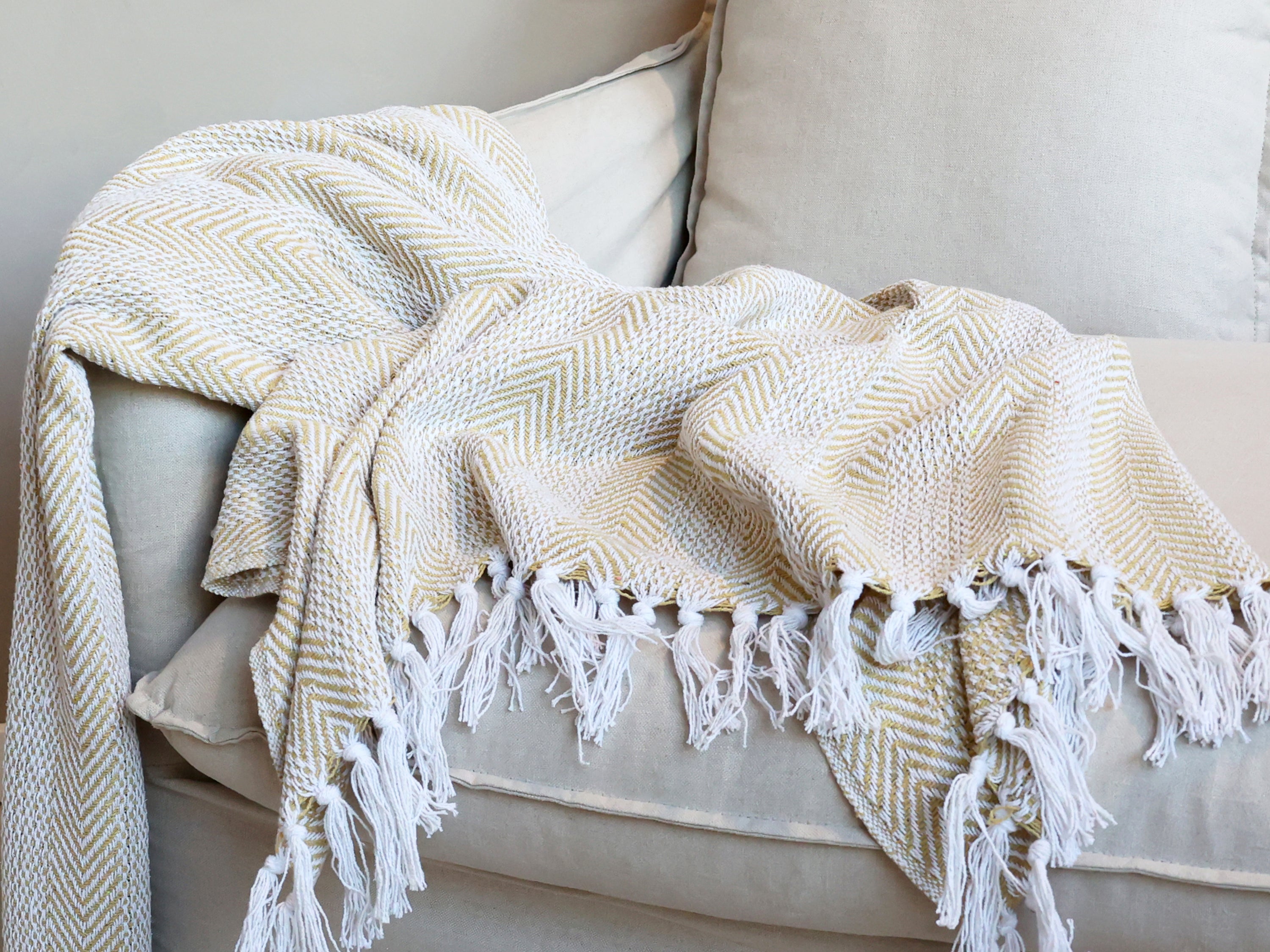 Chic Antique Plaid gold karamel mit Fransen als Tagesdecke auf Sofa im Hygge Wohnstil