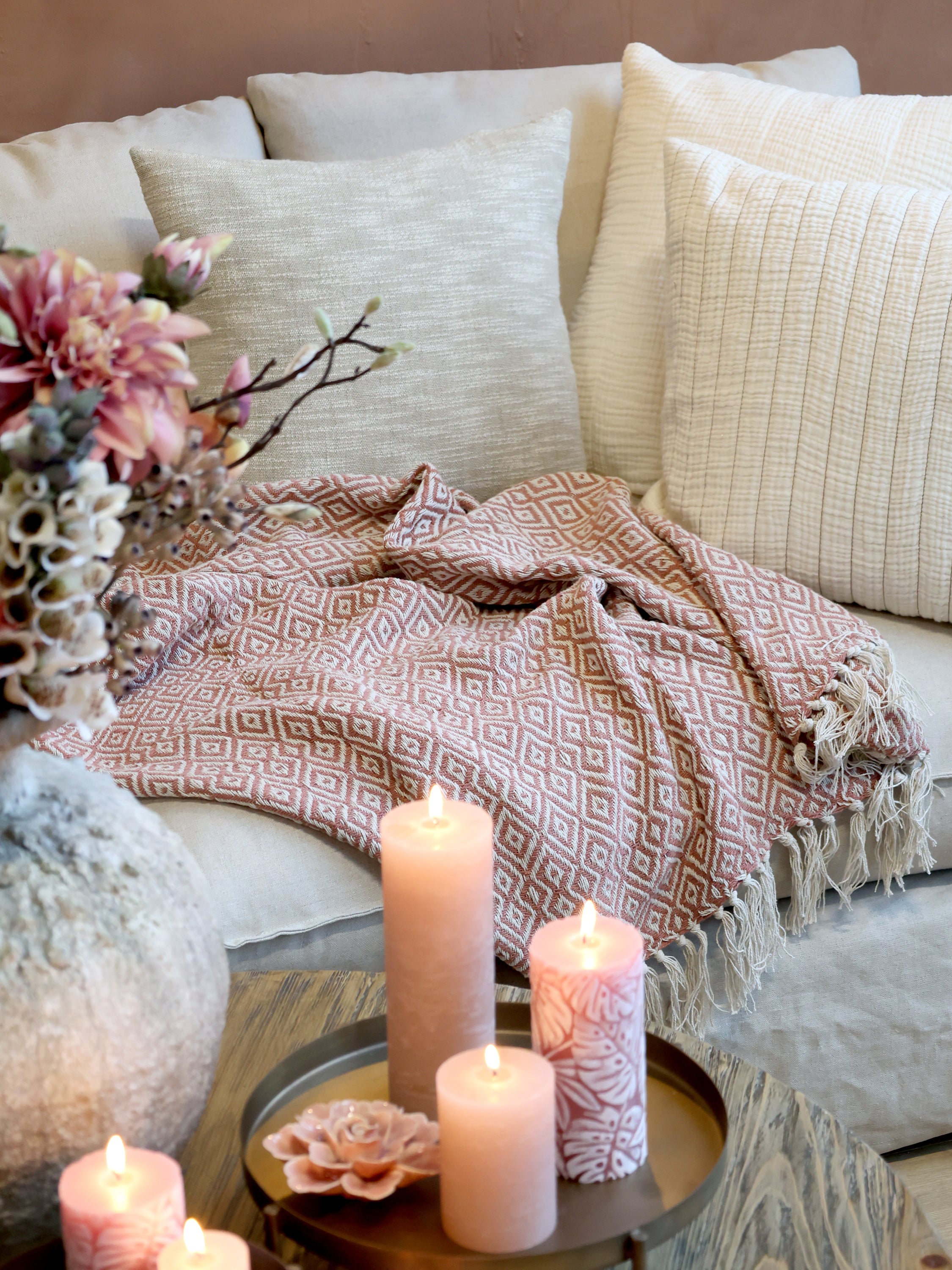 Chic Antique Plaid rosa dekorativ über Sofa im skandinavischen Wohnzimmer mit Kerzen und Hygge Atmosphäre