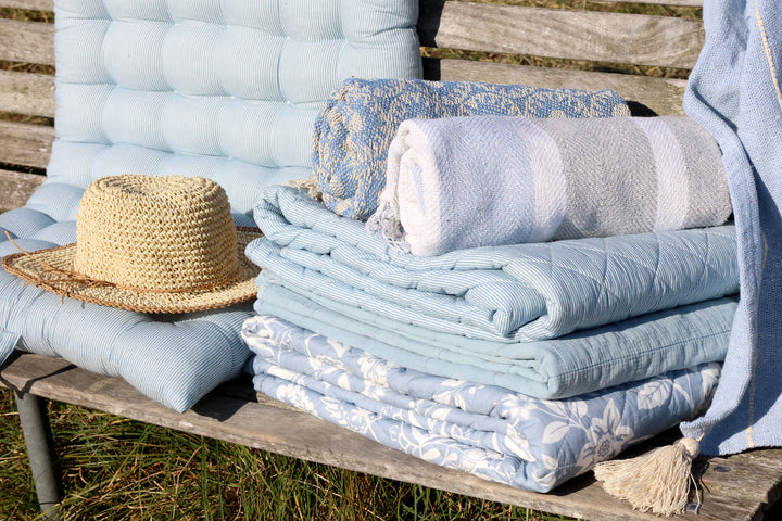Stapel Chic Antique Vintage Quilts in Sky Blue auf Holzbank im natürlichen Hygge Stil