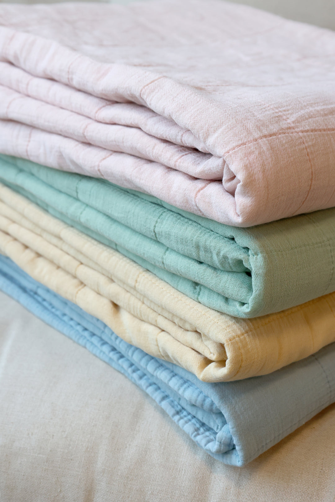 Stapel verschiedener Chic Antique Aix Vintage Quilts in sanften Pastellfarben