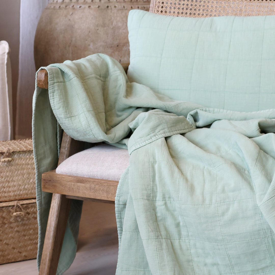 Chic Antique Quilt grün dekorativ über Sessel im nordischen Hygge Wohnstil mit Naturmaterialien