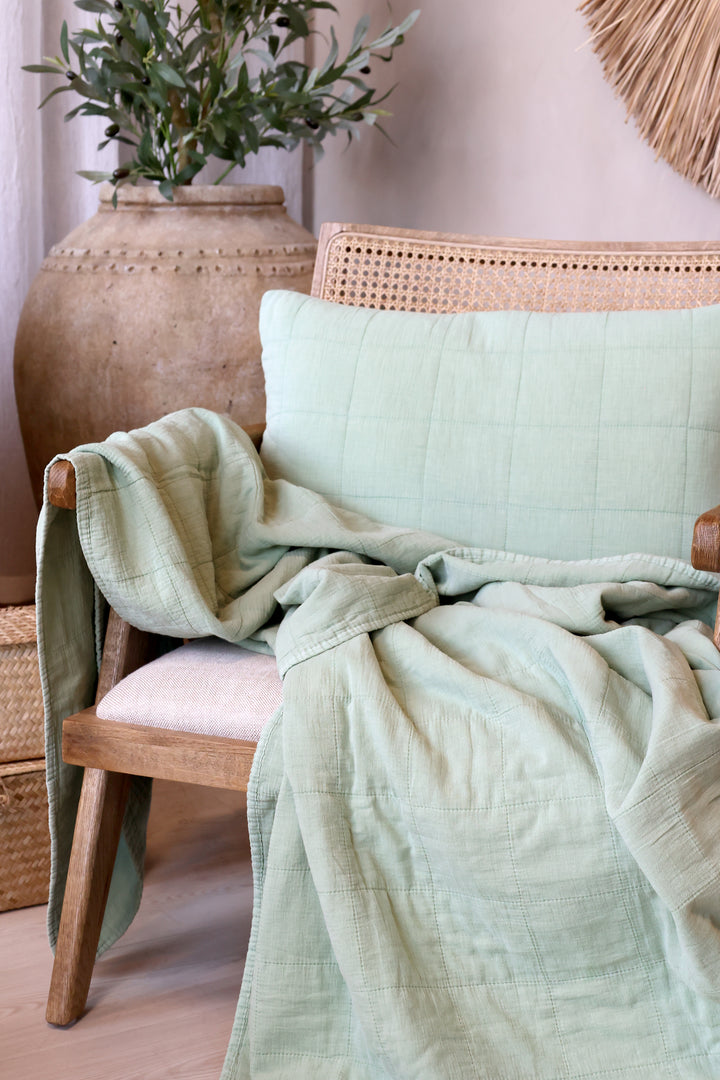 Chic Antique Aix Vintage Quilt grün als skandinavische Tagesdecke über einem Holzsessel im Landhausstil