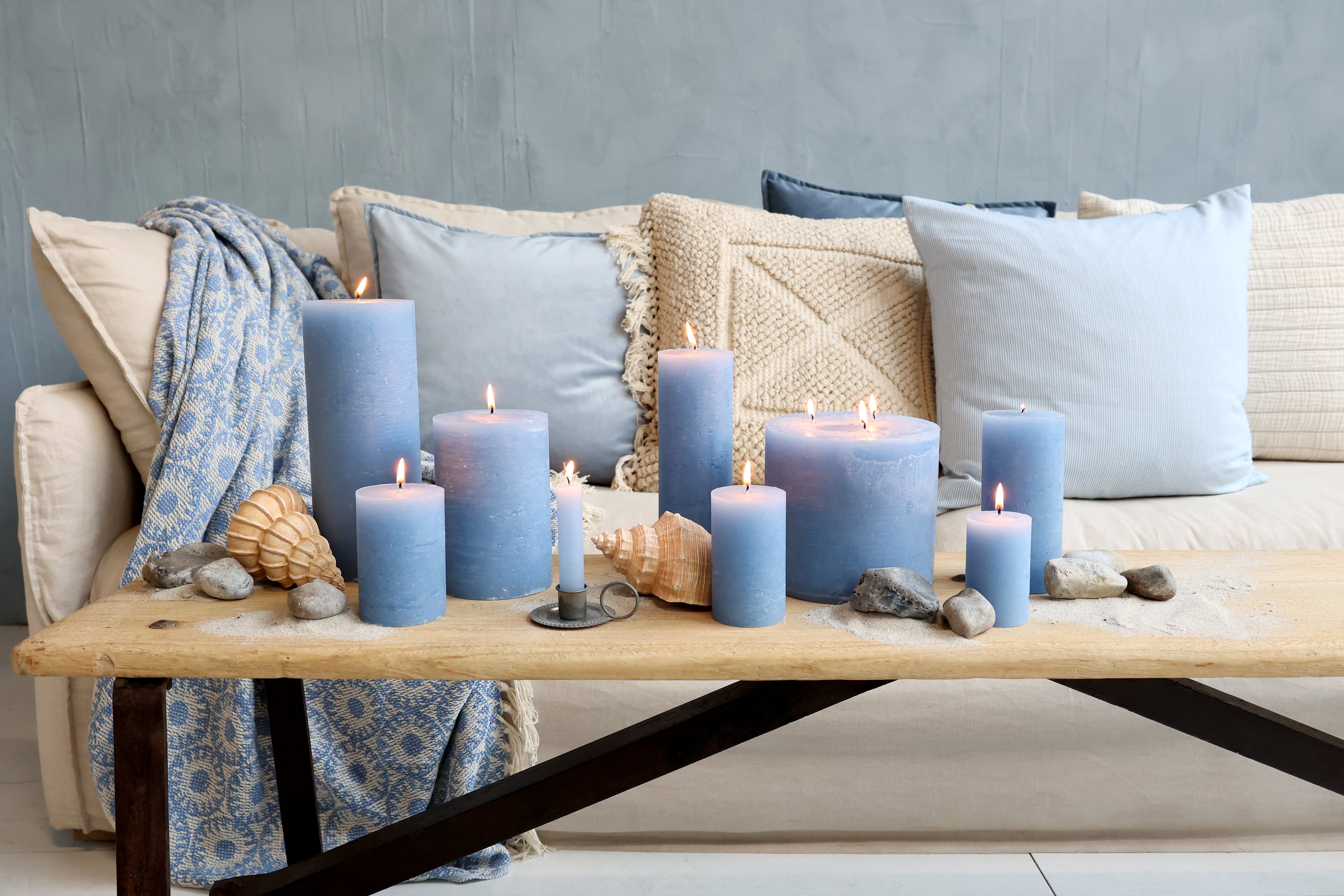 Chic Antique Aix Kissen mit maritimen Streifen in Sky Blue auf Sofa mit Kerzen und Muscheln im skandinavischen Küstenstil