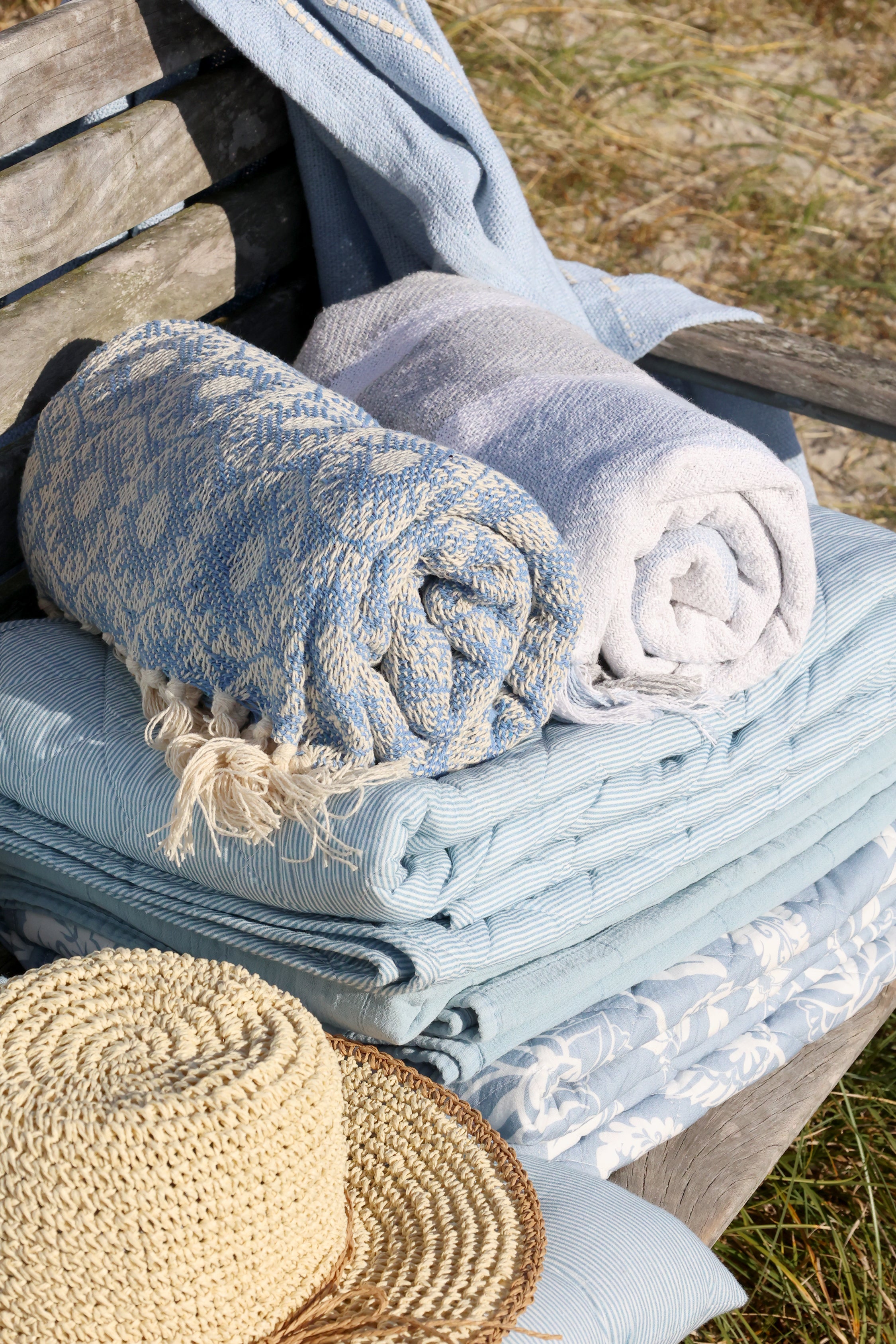 Chic Antique Aix Quilt Sky Blue mit floralem Muster dekorativ auf Holzbank im skandinavischen Landhausstil