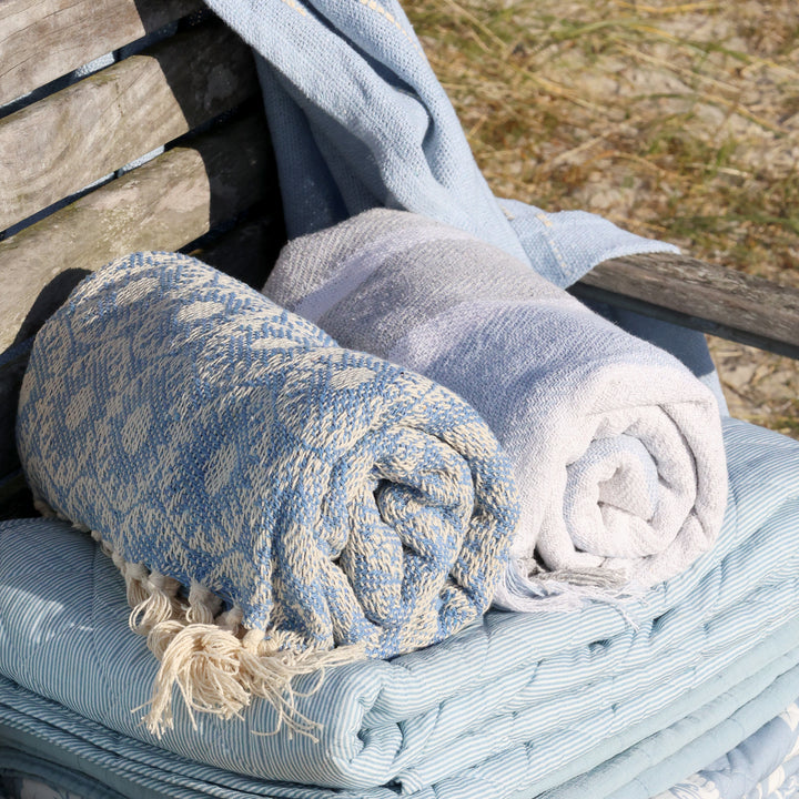 Chic Antique Aix Plaid ocean blau zusammengerollt mit Fransen als skandinavische Wohndecke