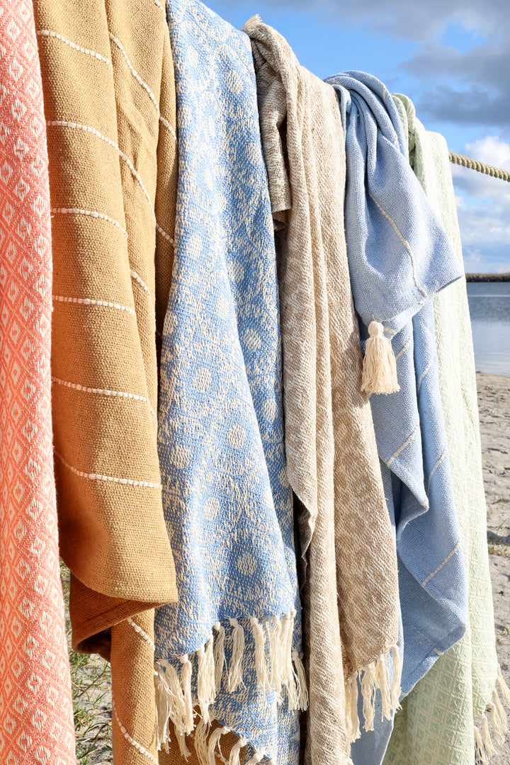 Chic Antique Plaids in mehreren Farben dekorativ am Strand aufgehängt im maritimen Wohnstil