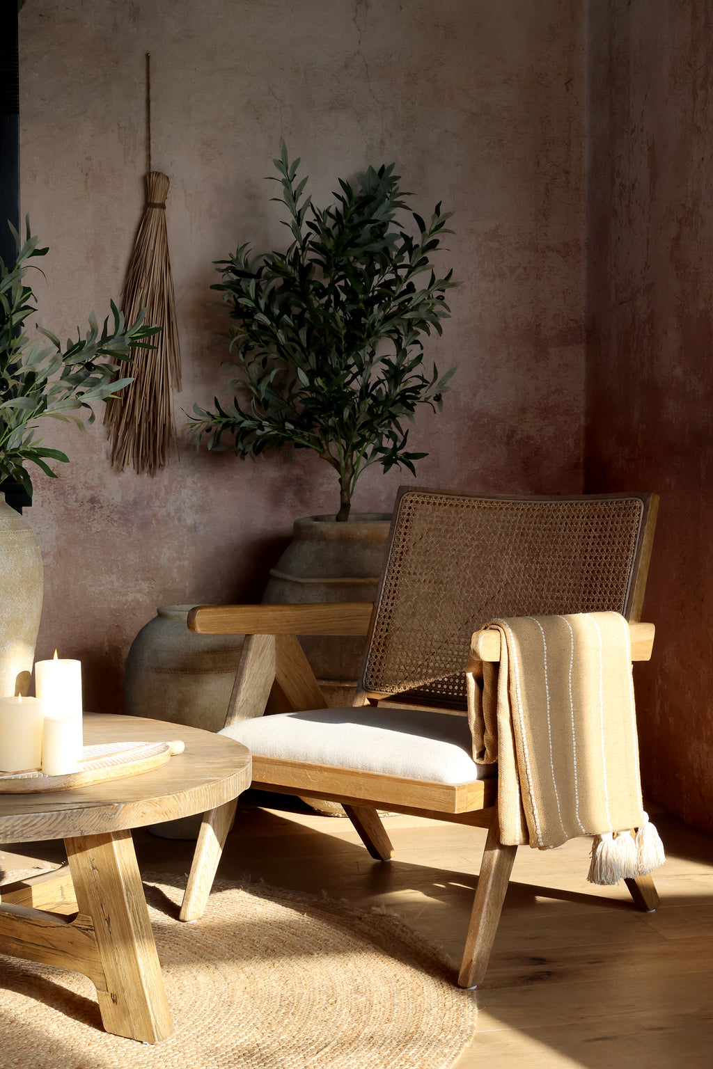 Chic Antique Plaid honig über Holzstuhl im warmen Hygge Wohnambiente mit Kerzen und Naturdeko