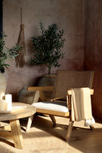 Chic Antique Plaid honig über Holzstuhl im warmen Hygge Wohnambiente mit Kerzen und Naturdeko