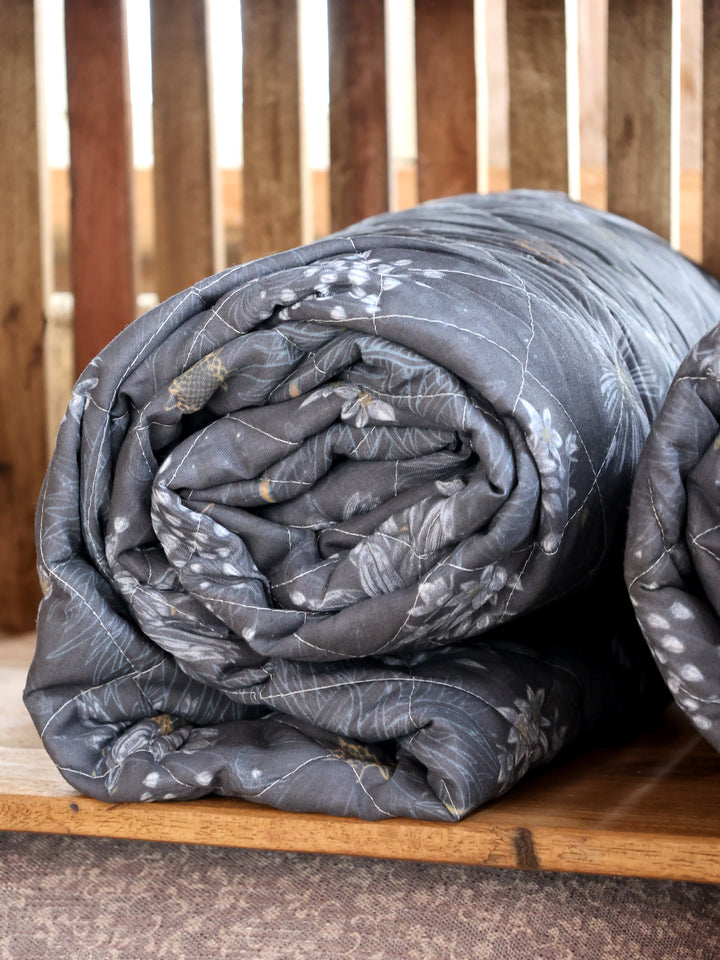 Chic Antique Aix Quilt Midnight mit Blumenmuster gerollt auf Holzregal im skandinavischen Landhausstil
