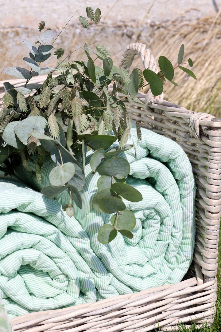 Chic Antique Aix Quilt grün weiß gestreift im Korb mit Eukalyptus im skandinavischen Wohnstil