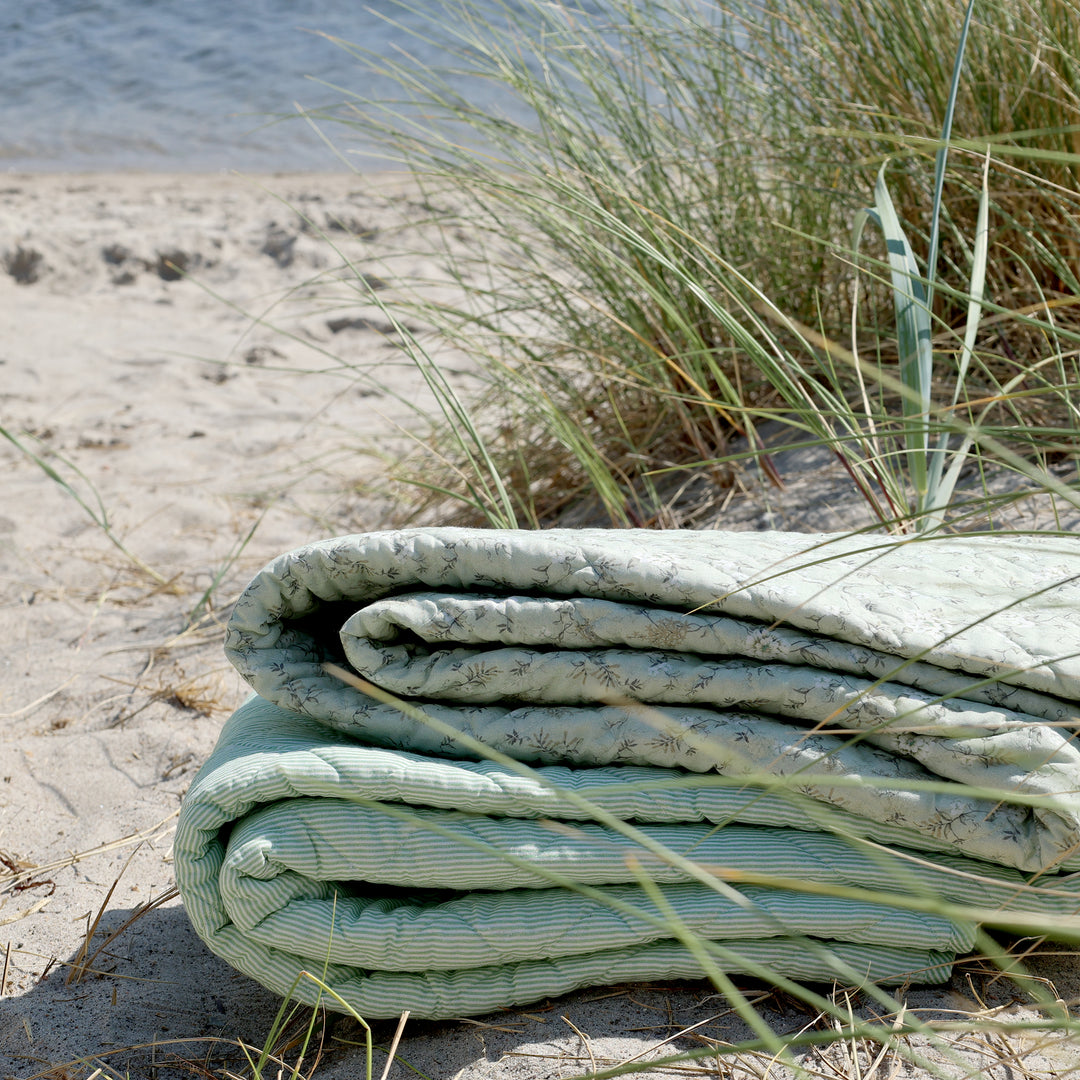 Chic Antique Aix Tagesdecke Grün Weiß mit floralem Muster gefaltet in Dünenlandschaft