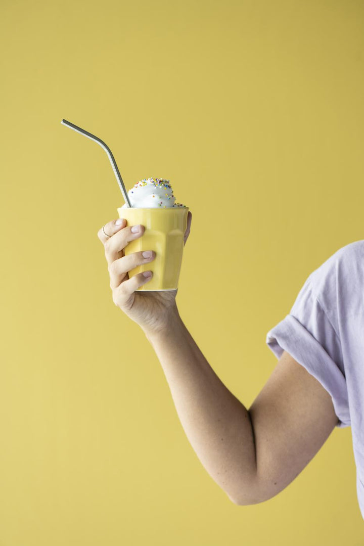IB Laursen Mynte Becher Lemonade Gelb in der Hand mit sommerlichem Getränk