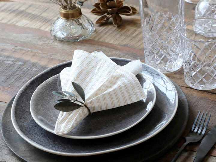 Chic Antique Papierserviette beige mit Streifen dekorativ gefaltet auf Teller bei Tischdekoration im skandinavischen Landhausstil
