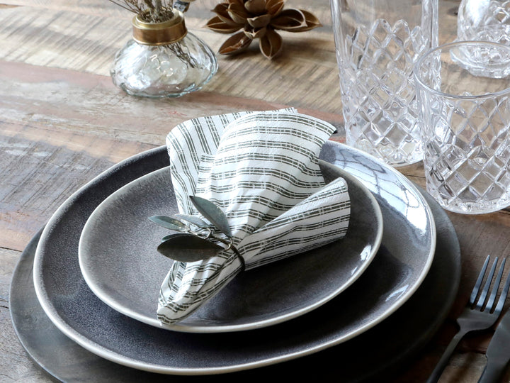 Chic Antique Papierserviette mit Streifen in Olive dekorativ gefaltet auf Teller bei Tischdekoration im skandinavischen Landhausstil