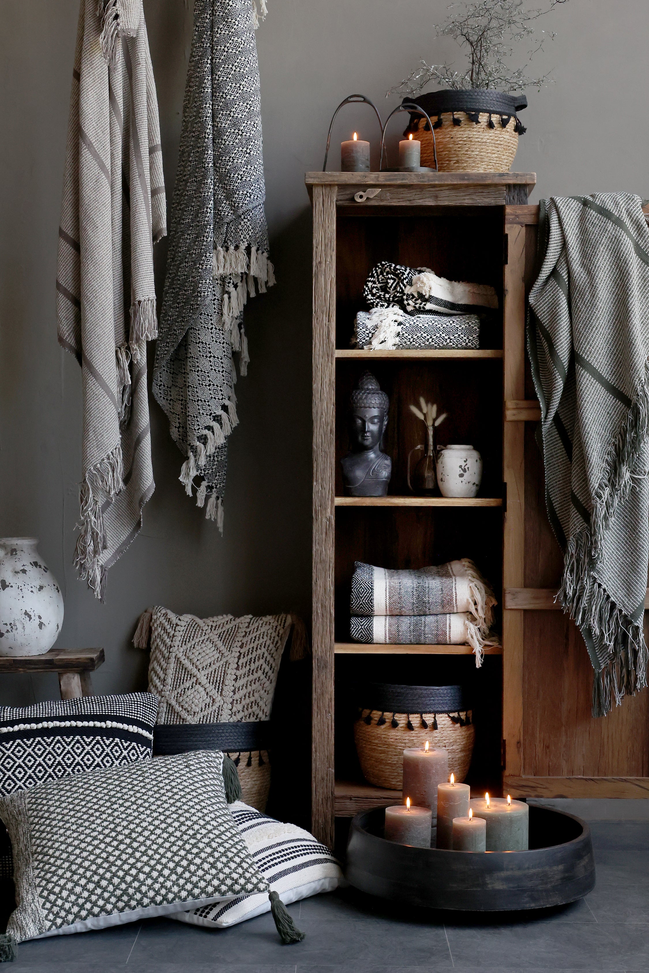 Chic Antique Grimaud Holzschrank Natur dekoriert mit Decken und Körben im Wohnraum