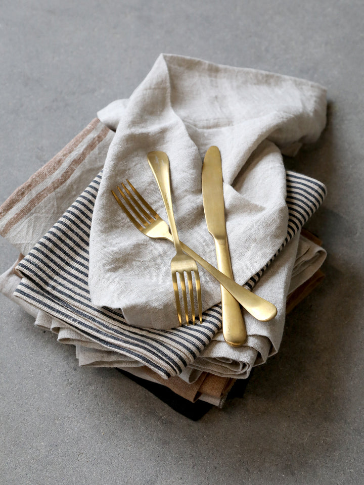 Chic Antique Nordique Gold Besteck Set 4-teilig auf Leinenservietten