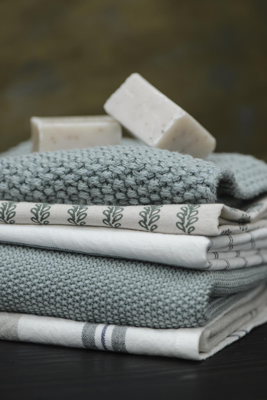 Ib Laursen Mynte Topflappen staubig grün gestrickt mit Geschirrtüchern und Naturseife im skandinavischen Küchenstil