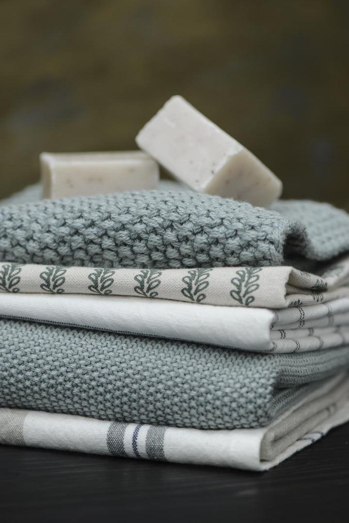 Ib Laursen Mynte Topflappen staubig grün gestrickt mit Geschirrtüchern und Naturseife im skandinavischen Küchenstil