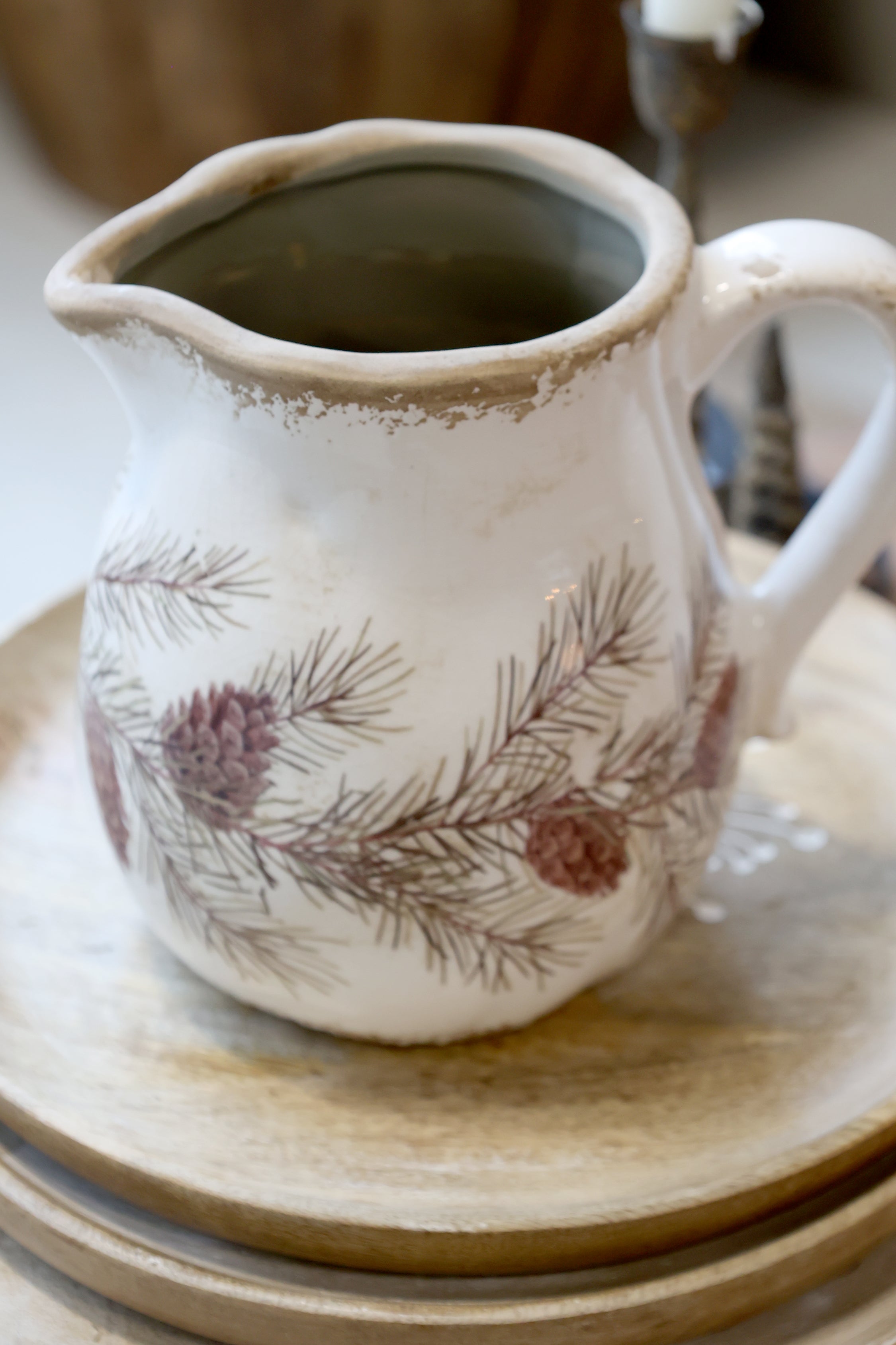 Detailaufnahme der Chic Antique Keramikkanne mit Tannengirlanden und Zapfen im rustikalen Landhausstil