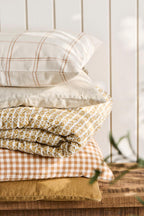 IB Laursen Kissenbezug Luca 50x50 cm mit rustikbraunem Karomuster kombiniert mit weiteren Wohntextilien im skandinavischen Stil
