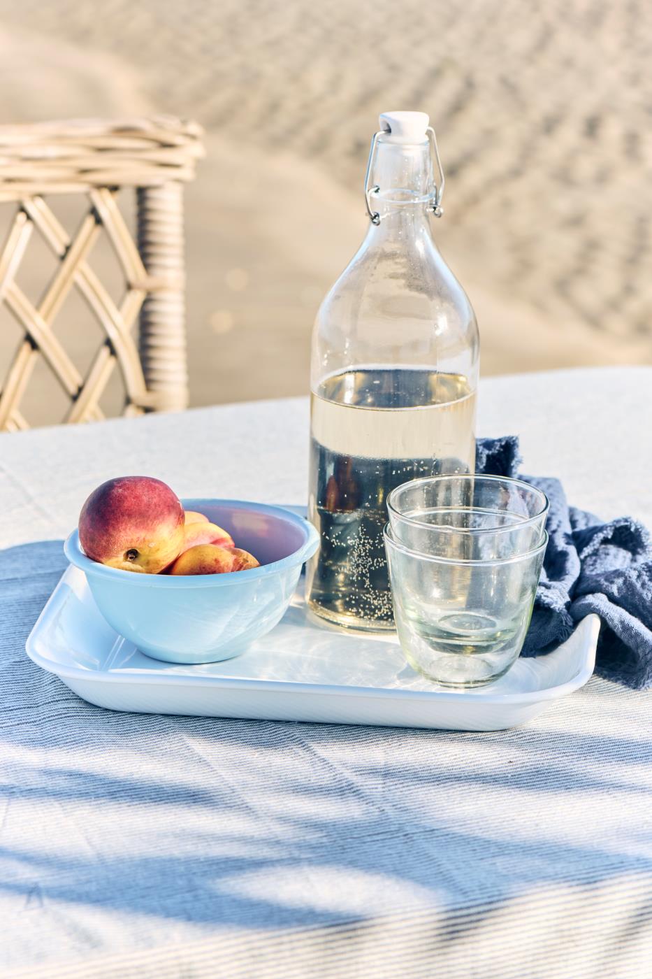Ib Laursen Tischdecke Charlie blau weiß gestreift mit Tablett, Glasflasche und Pfirsichen auf Sommertisch
