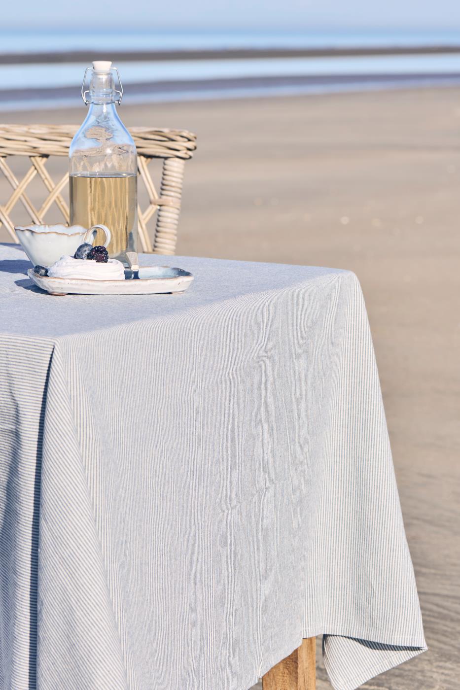 Ib Laursen Tischdecke Charlie blau weiß gestreift auf Tisch am Strand im skandinavischen Sommerstil