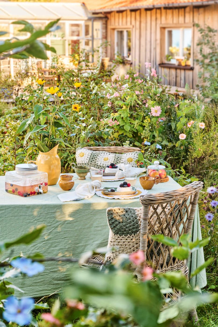 Ib Laursen Tischdecke Emil grün gestreift auf sommerlich gedecktem Tisch im Garten mit Blumen