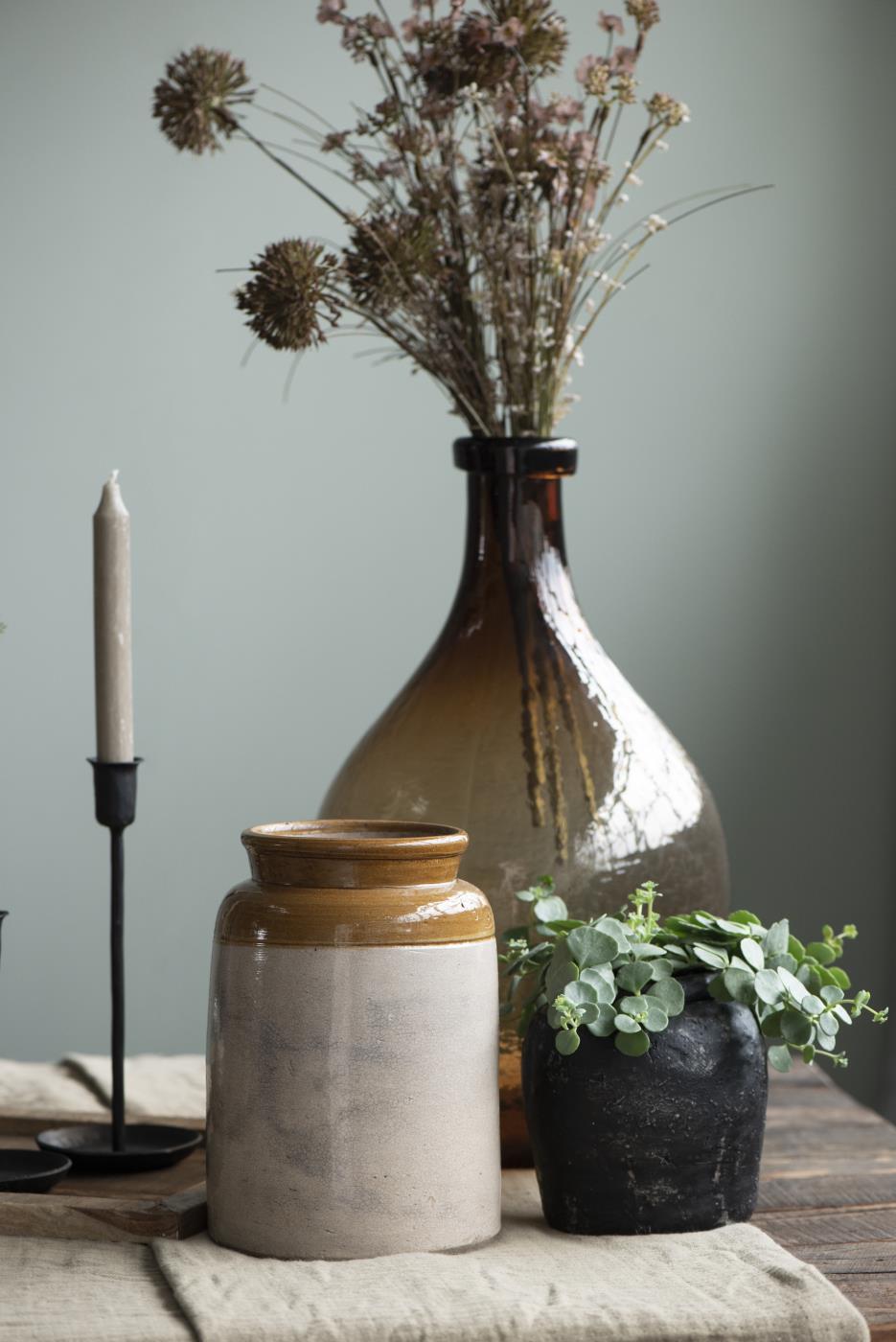 Ib Laursen Glasballon braunes Glas mit Trockenblumen auf Tisch dekoriert im Vintage Stil