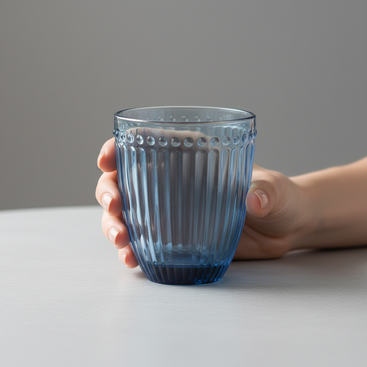 GreenGate Wasserglas Alice Blau in der Hand gehalten mit geriffelter Glasstruktur