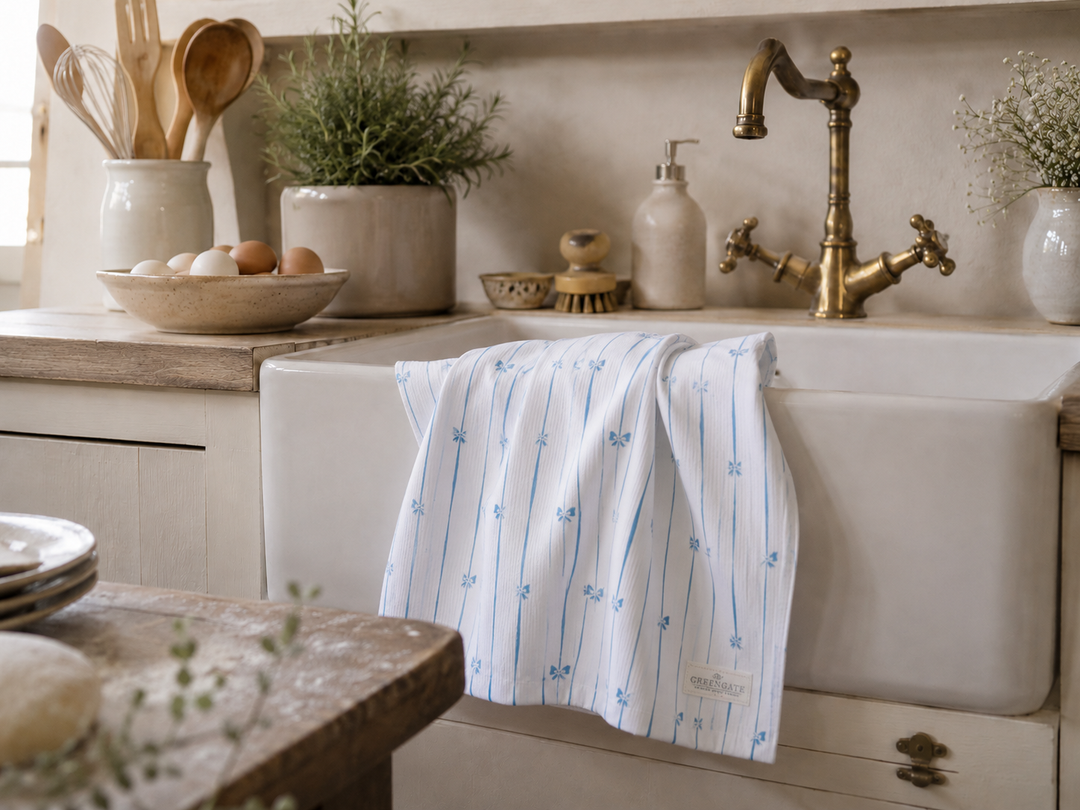 GreenGate Geschirrtuch mit blauem Schleifenmuster in heller Landhausküche an nostalgischer Spüle dekoriert
