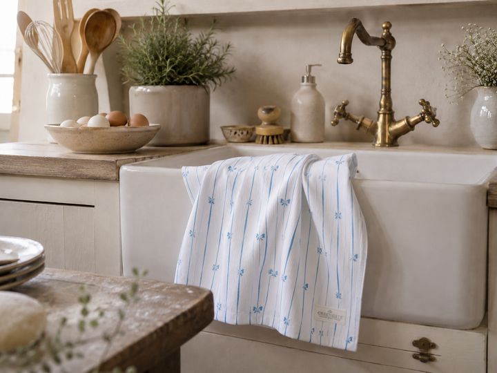GreenGate Geschirrtuch mit blauem Schleifenmuster in heller Landhausküche an nostalgischer Spüle dekoriert