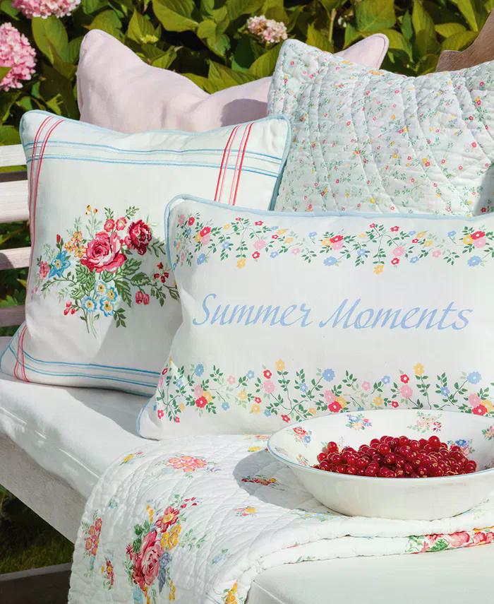 GreenGate Kissen mit Blumenmuster und Schriftzug Summer Moments im skandinavischen Landhausstil dekoriert auf Gartenbank