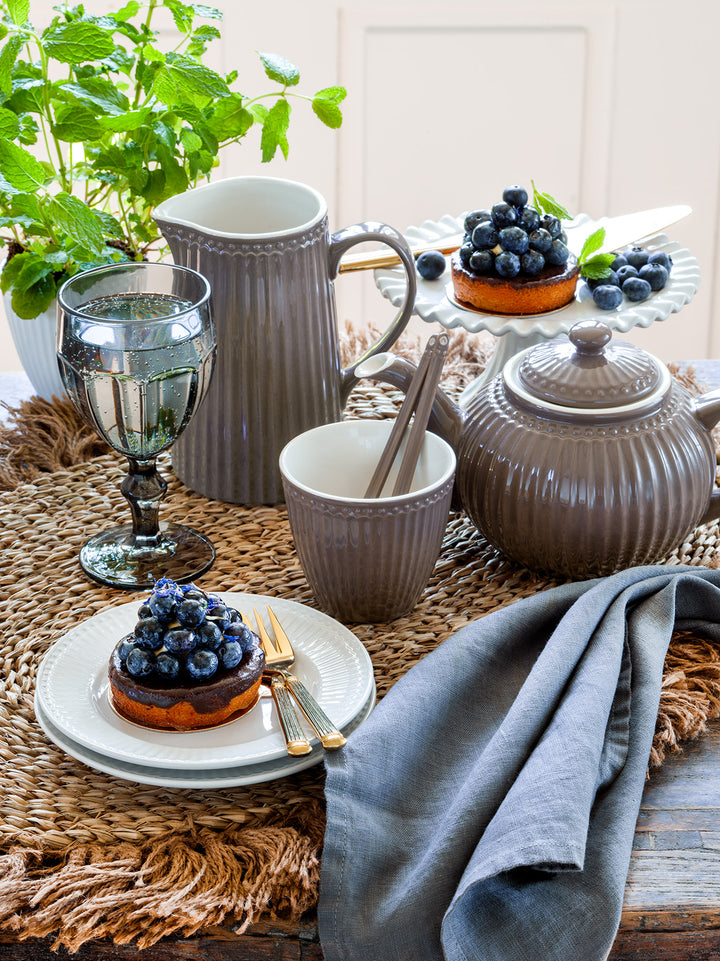GreenGate Krug Alice Schokolade 1 Liter neben Teekanne und Dessert auf skandinavisch gedecktem Tisch