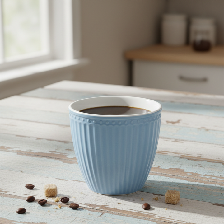 GreenGate Latte Becher Alice Himmelblau mit Kaffee auf rustikalem Holztisch mit Zuckerwürfeln und Kaffeebohnen