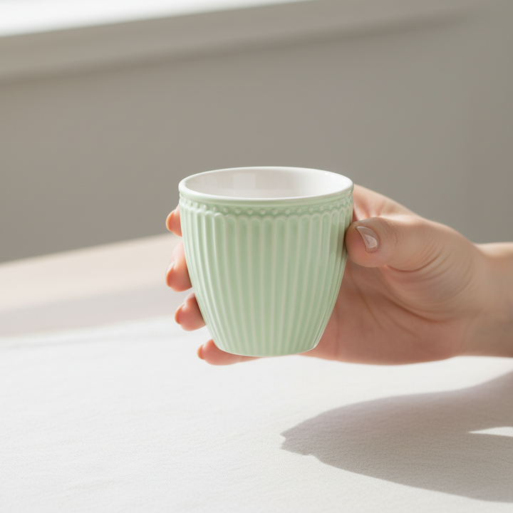 GreenGate Mini Latte Becher Alice Hellgrün aus Porzellan in der Hand gehalten