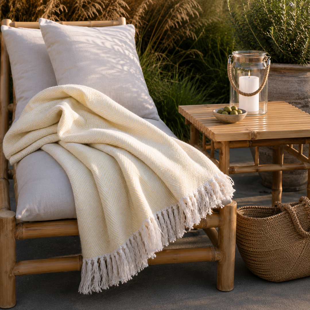 Chic Antique Aix Plaid Gelb auf heller Bambusliege im skandinavischen Outdoor Stil mit Laterne und Naturmaterialien