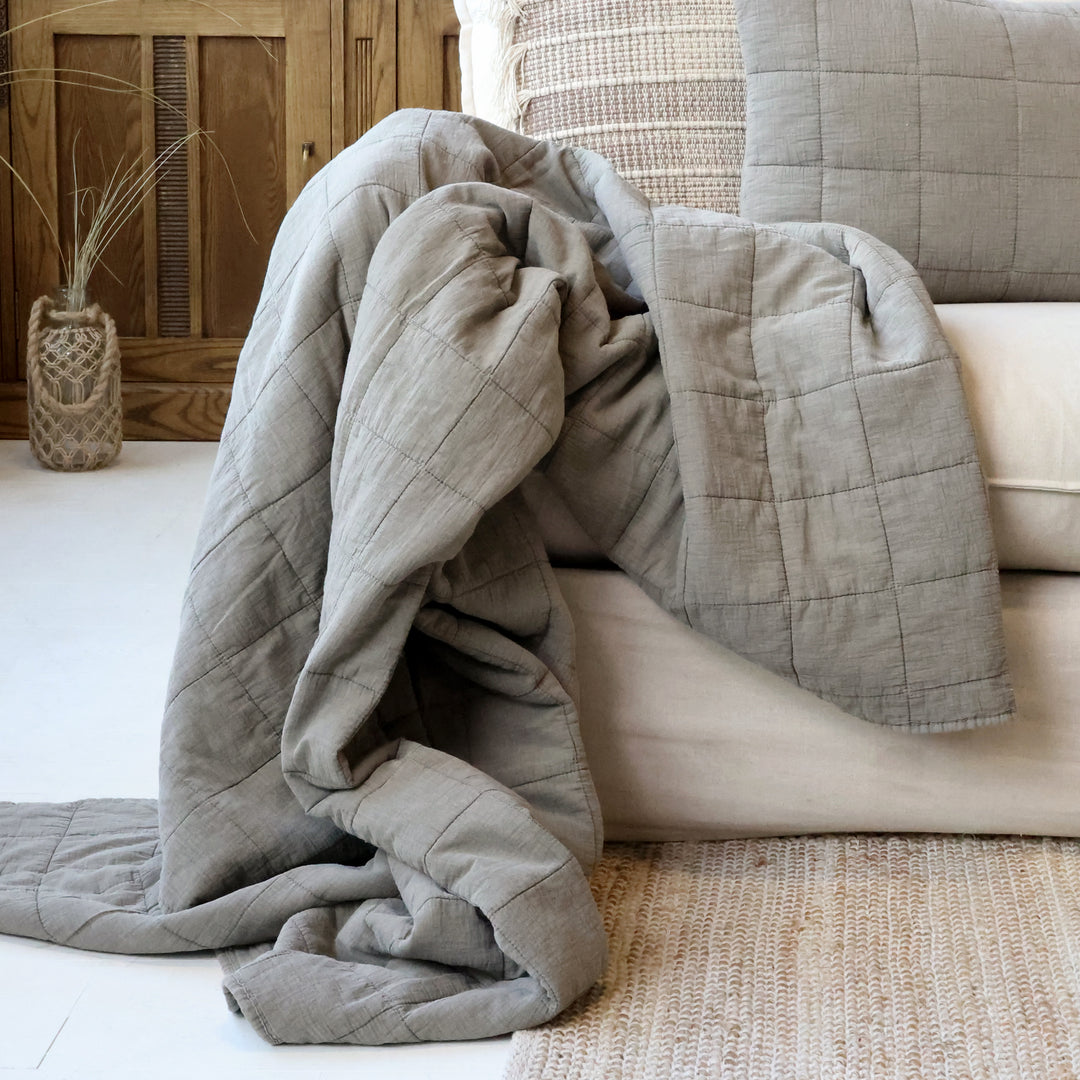 Lattefarbener Chic Antique Aix Quilt locker über Sofa im skandinavischen Landhausstil drapiert