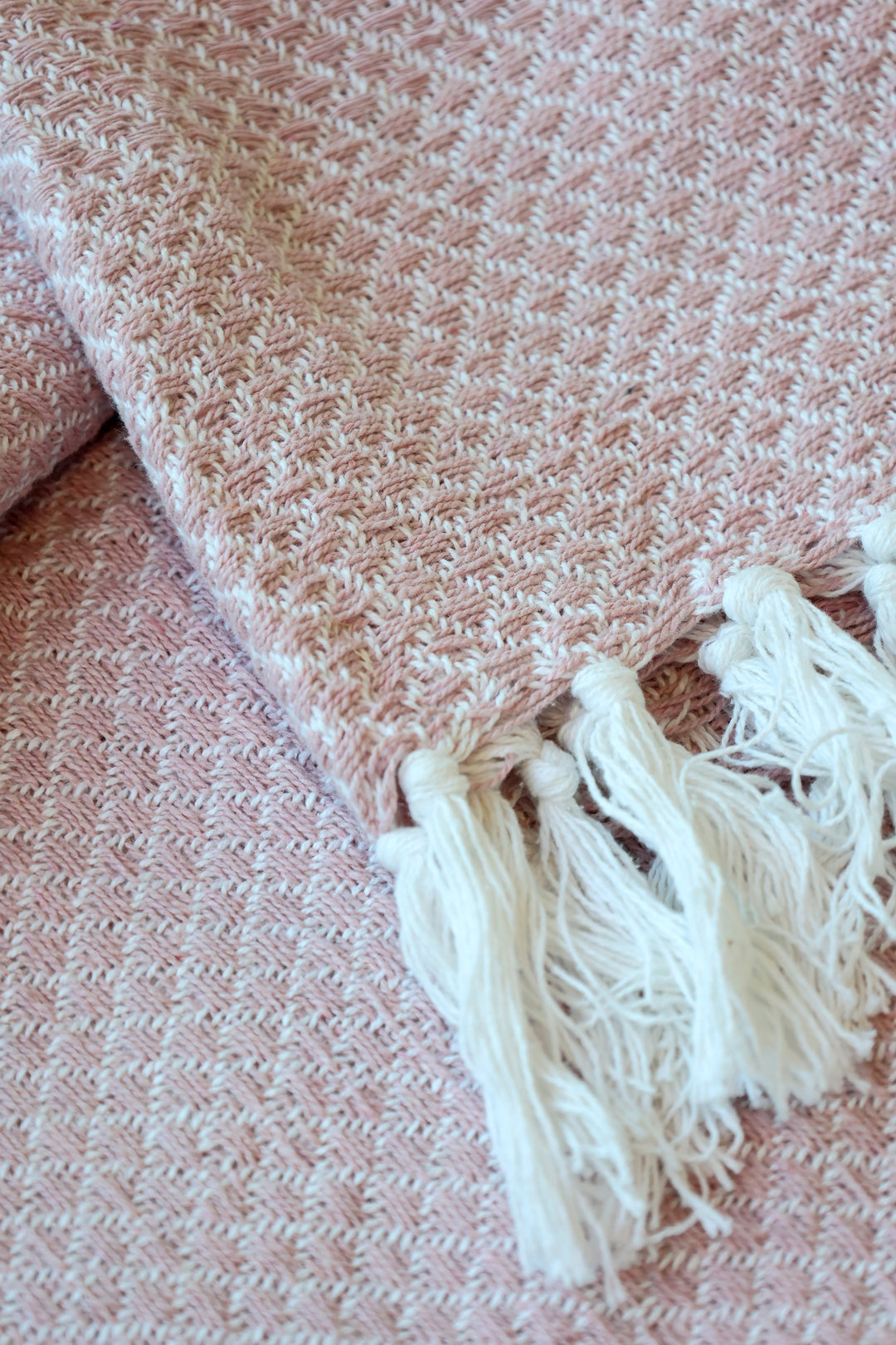 Detailaufnahme des Chic Antique Aix Plaids Rosa mit gewebter Struktur und weißen Fransen