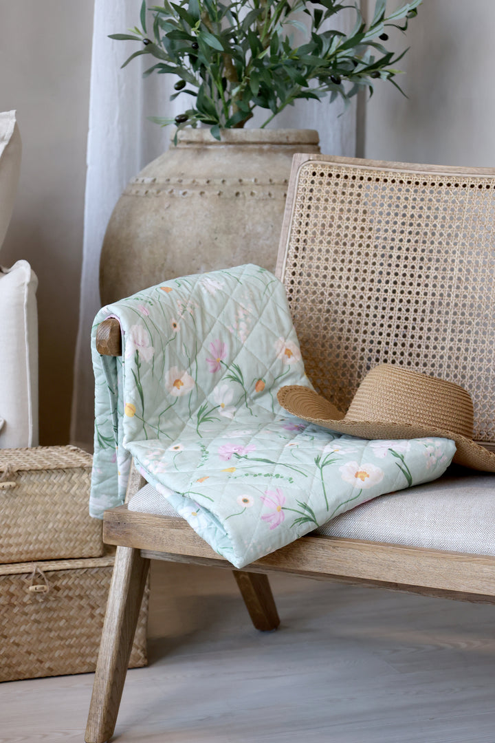Chic Antique Aix Vintage Quilt mit floralem Blumenmuster in Grün dekorativ auf einem Rattansessel