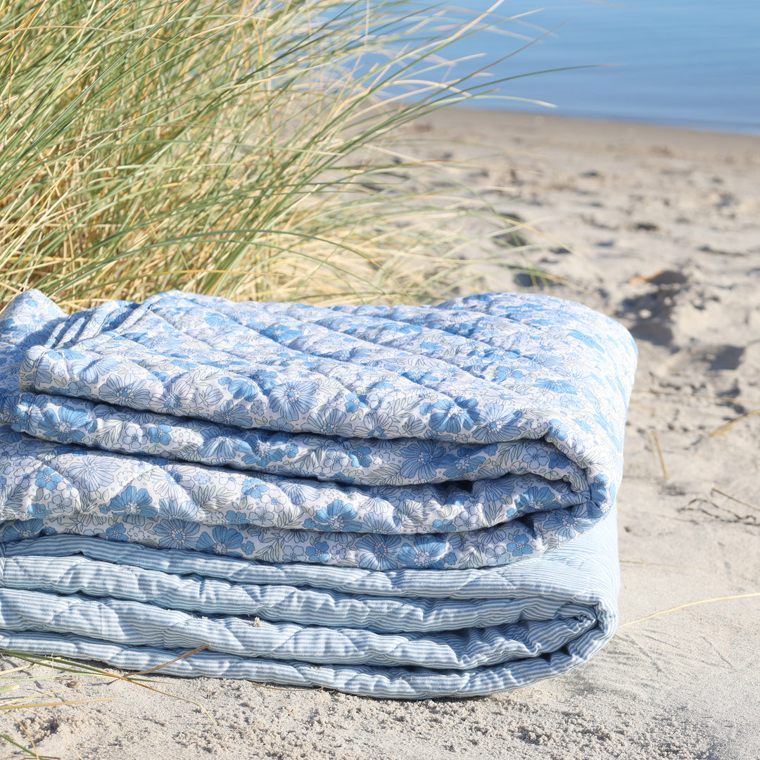 Chic Antique Aix Vintage Quilt mit blauem Blumenmuster dekoriert mit Kissen am Strand