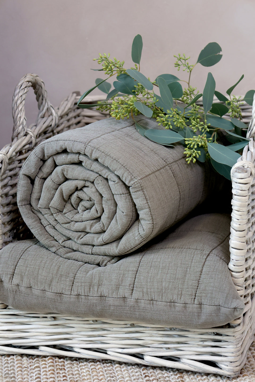 Chic Antique Aix Vintage Quilt Latte gerollt im Korb mit Eukalyptus dekoriert