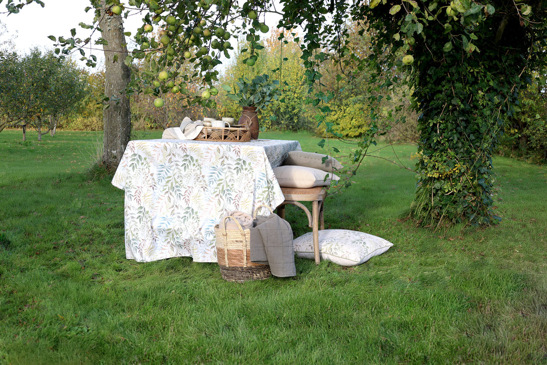 Chic Antique Aix Tischdecke Creme mit Blattmuster dekoriert auf Gartentisch im Landhausstil
