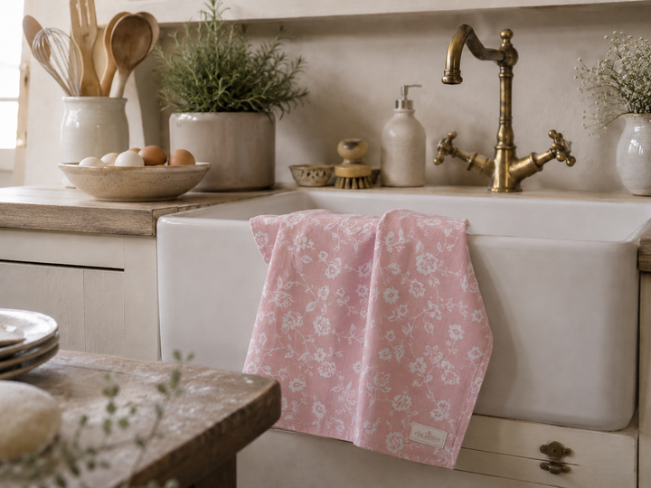 Chic Antique Geschirrtuch mit rosa Blumenmuster am weißen Spülbecken in heller Landhausküche im Shabby Chic Stil