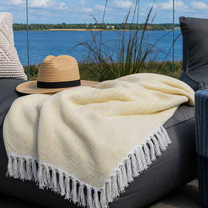 Hellgelbes Chic Antique Plaid auf gemütlicher Terrasse am Wasser im skandinavischen Stil