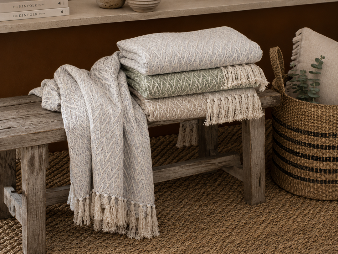 Chic Antique Plaid Tagesdecke Französisch Grau auf rustikaler Holzbank mit natürlichen Stoffstrukturen und Fransen im Shabby Chic Stil
