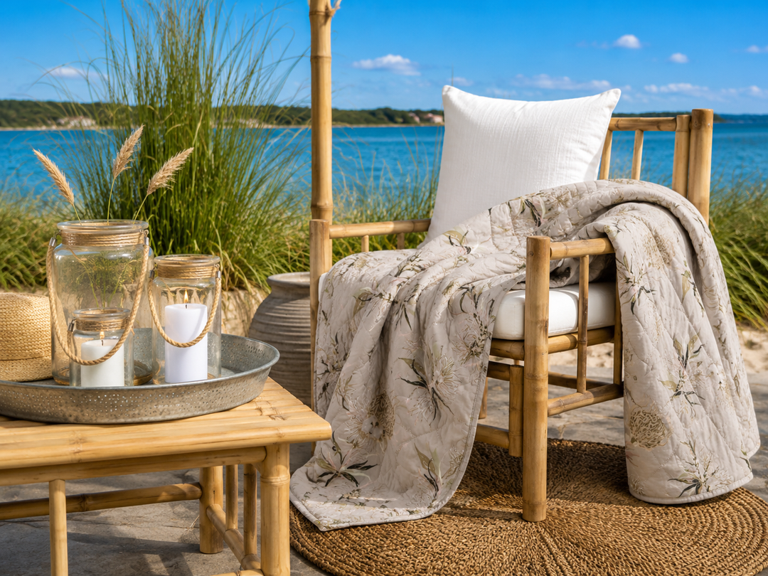 Beigefarbener Quilt mit floralem Muster im natürlichen Boho Stil am Wasser